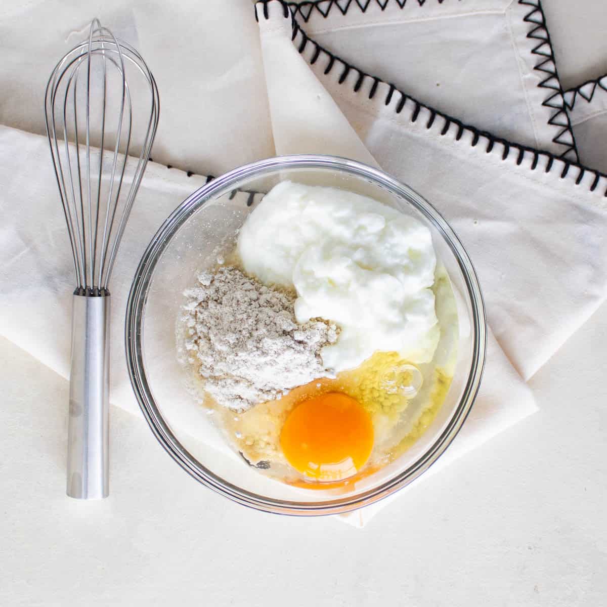 Oat flour, egg and yogurt in a bowl.