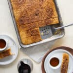 A pan of sheet pan pancakes and a plates of pancakes on a table.