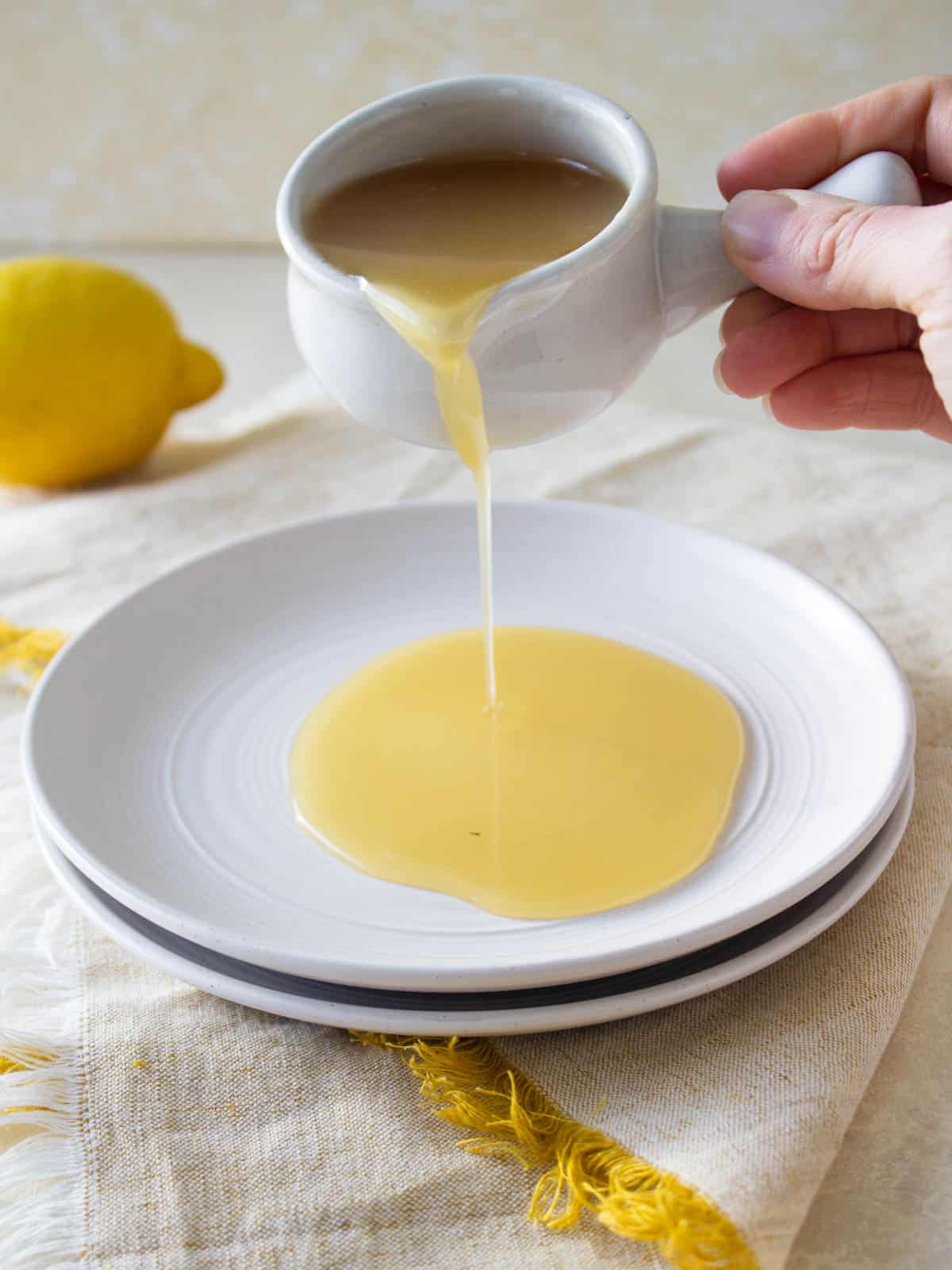 Pouring lemon glaze onto a plate.