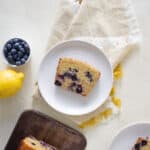 A slice of whole wheat blueberry bread on a white plate.