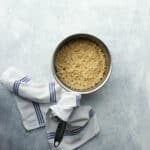 Cooked cracked wheat in a small pot with a towel tied around the handle.