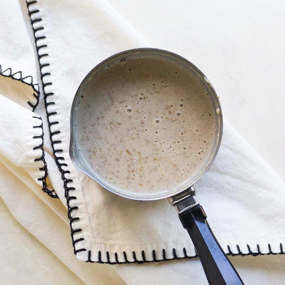 Cracked wheat and milk porridge in a pan.