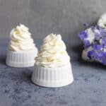 Whipped cream piped on top of upside down ramekins.