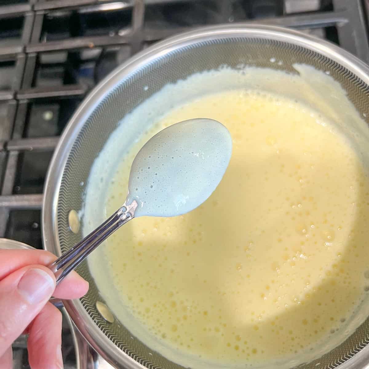 A spoon showing custard coating the back of a spoon.