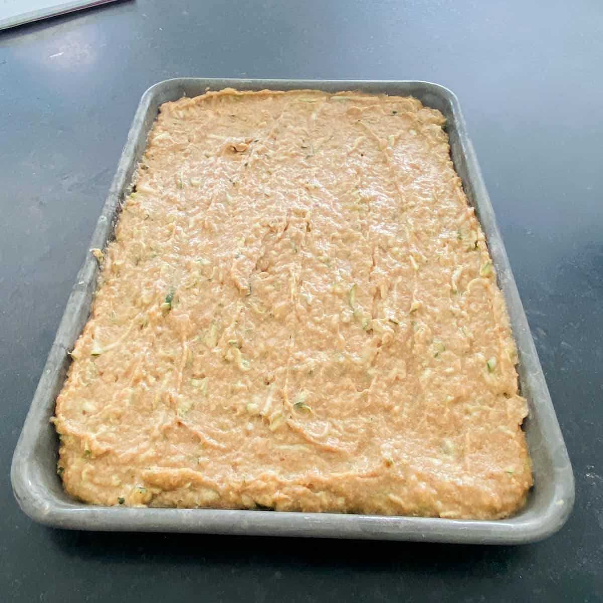 Zucchini cake batter in a sheet pan.