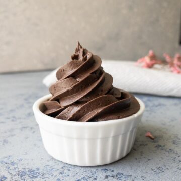 Dark chocolate frosting piped into a small white dish.