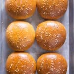 Golden brown hamburger buns with sesame seeds on top.