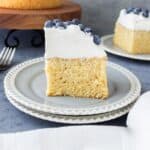 A slice of whole wheat sponge cake with whipped cream and blueberries on top.