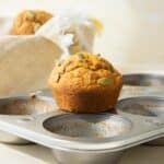 A pumpkin muffins sitting on top of a muffin tin.