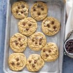Chocolate chip cookies arranged on a baking sheet.