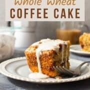 A slice of whole wheat coffee cake drizzled with glaze on a plate.