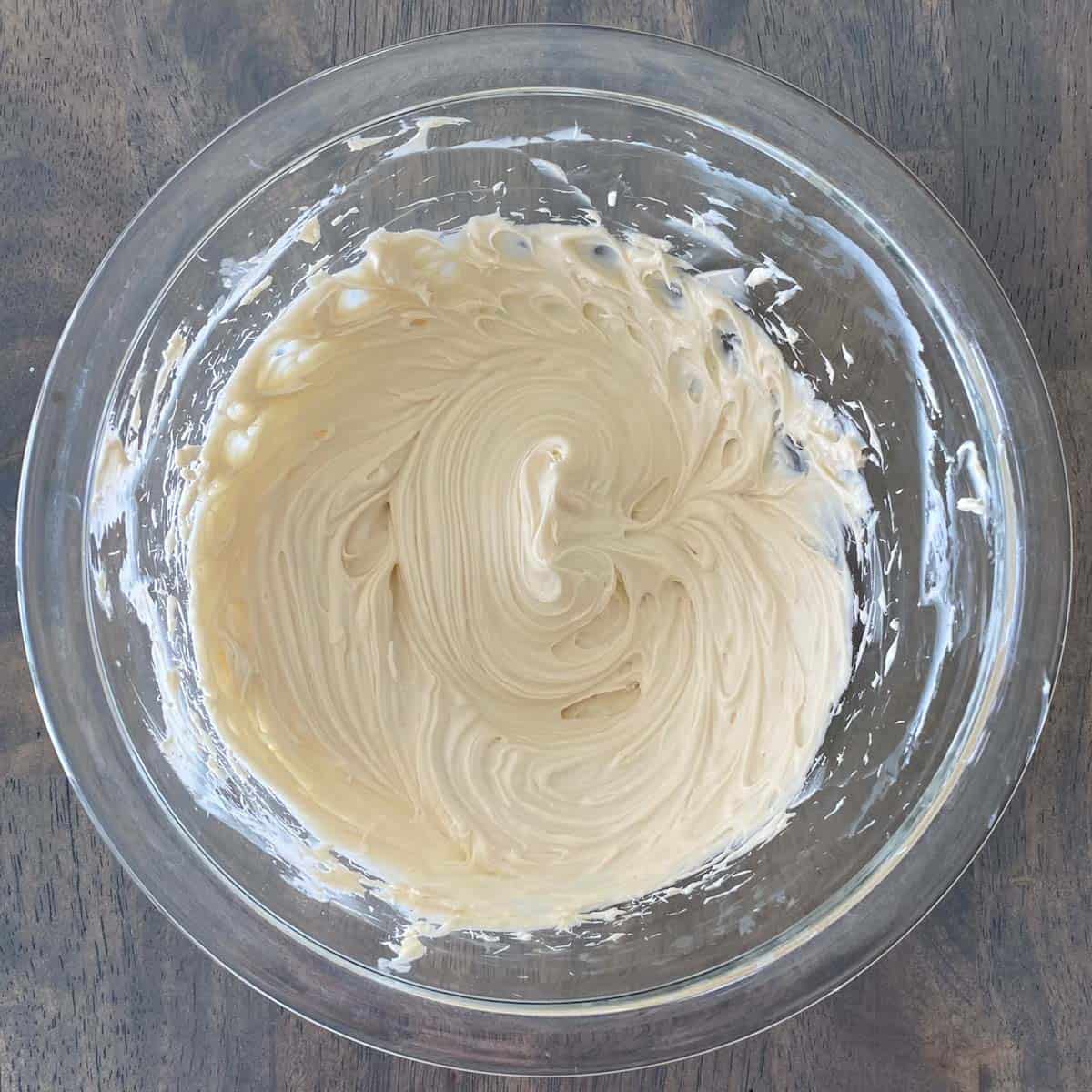 Cream cheese beaten smooth in a bowl.