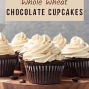 Whole wheat chocolate cupcakes with frosting on a wooden plate with text overlay.