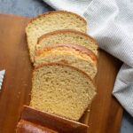 A loaf of whole wheat brioche bread with slices cut off the end and laying down.